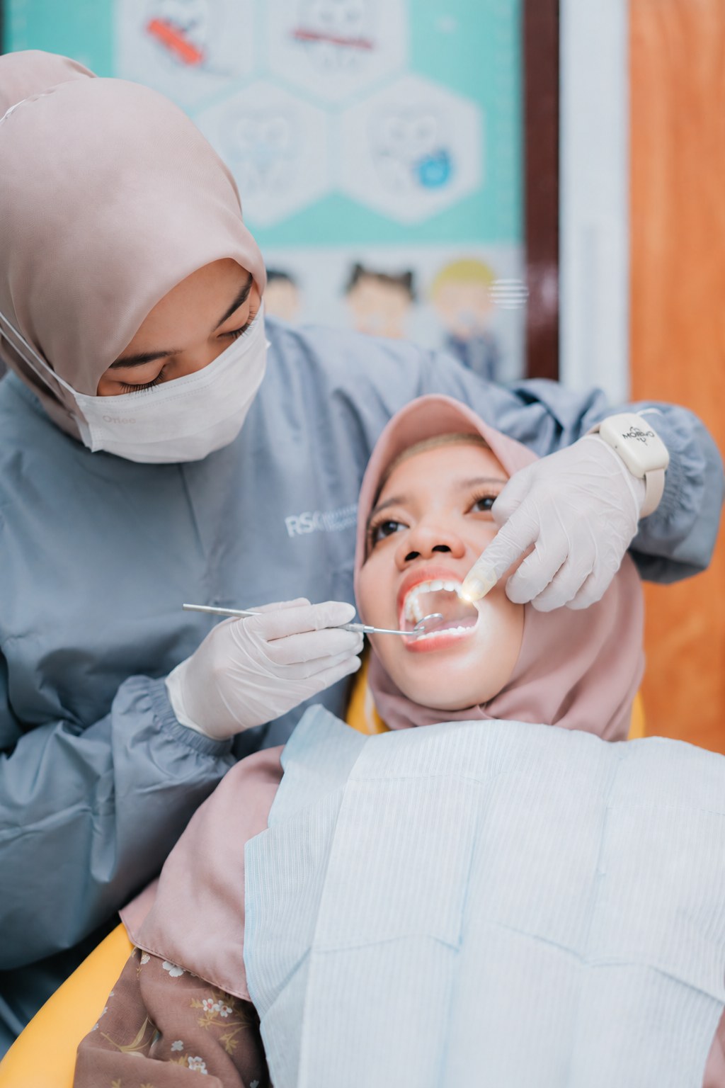 Dokter gigi memeriksa rongga mulut pasien, visual perangkat disesuaikan ke MORVO 2026